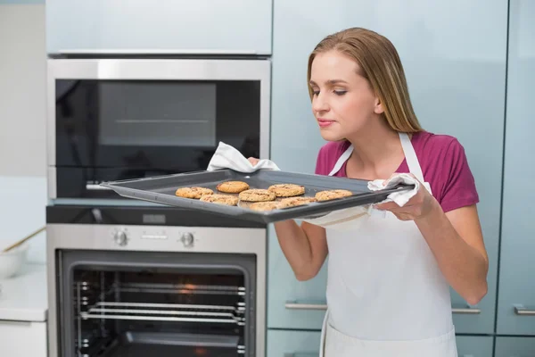 Casual aantrekkelijke vrouw ruiken bakken lade met cookies — Stockfoto