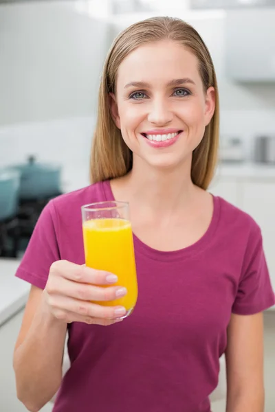 Mulher casual feliz segurando vidro de suco de laranja — Fotografia de Stock