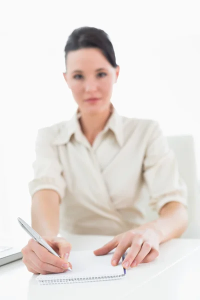 Retrato de una joven empresaria escribiendo notas por computadora portátil Imagen de stock