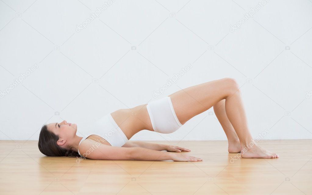 Woman doing the bridge pose in fitness studio