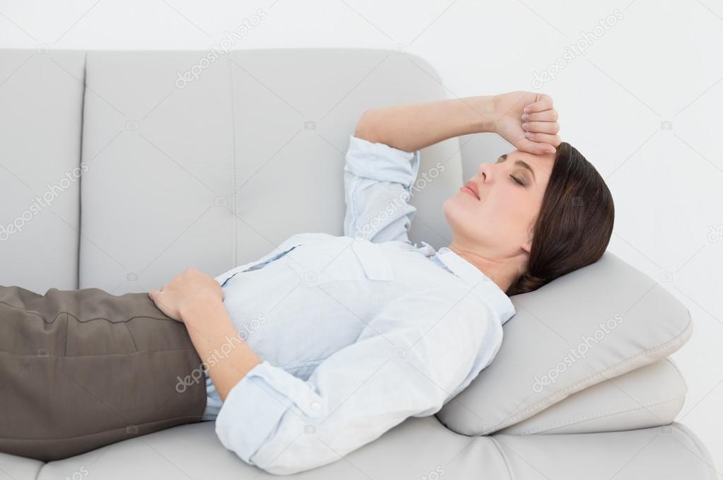 Well dressed young woman resting on sofa