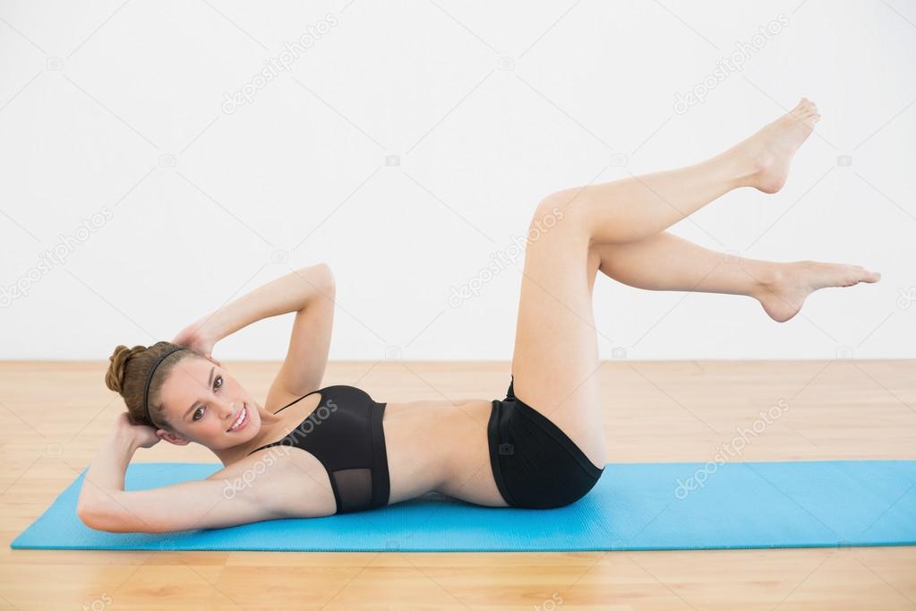 Beautiful slender woman wearing sportswear training lying on the floor