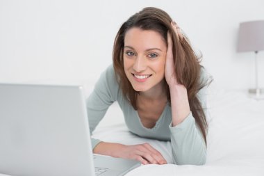 dizüstü bilgisayar kullanan yatakta rahat rahat kadın