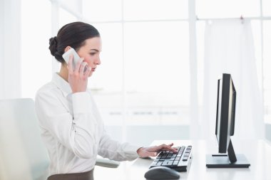 cep telefonu ve bilgisayar kullanarak iş kadını