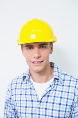 Sarı baret takmış gülümseyen bir tamirciyle portresi