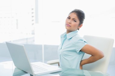 iş kadını ofiste sırt ağrısı muzdarip