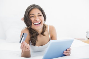 casual kadın yatakta online alışveriş yaparken