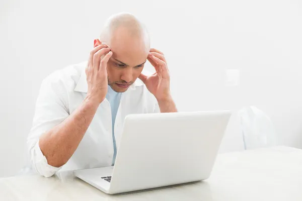 Hombre casual preocupado concentrado usando el ordenador portátil en el escritorio — Foto de Stock