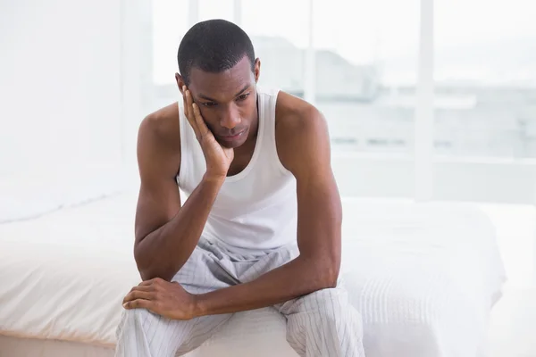 Homme afro réfléchi assis sur le lit — Photo