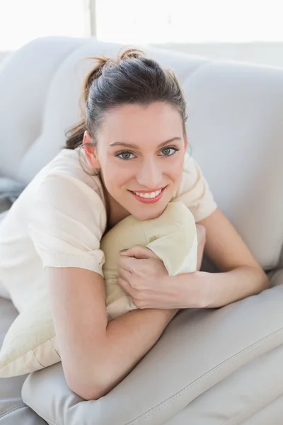 Portret van een lachende ontspannen casual vrouw liggend op de Bank — Stockfoto