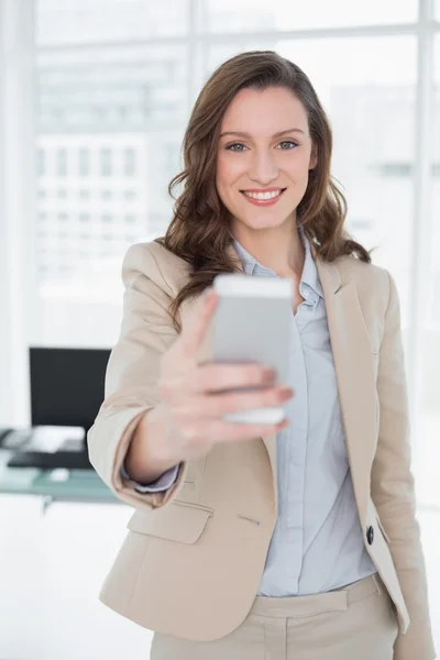 Sonriente elegante mujer de negocios de mensajes de texto en la oficina — Foto de Stock