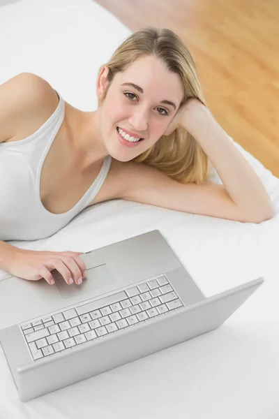 Mujer rubia alegre usando su cuaderno sonriendo a la cámara —  Fotos de Stock