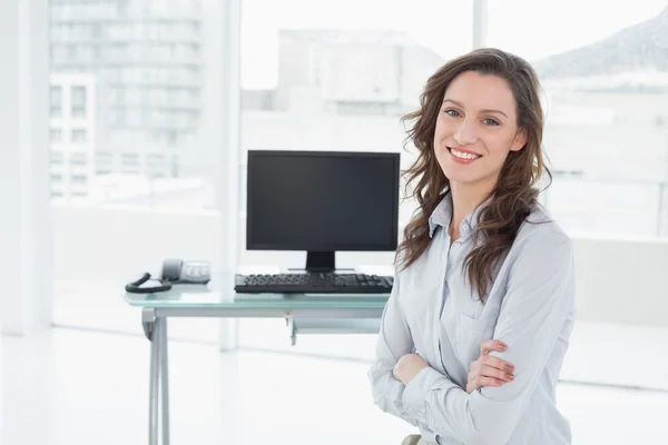 Femme d'affaires souriante devant l'ordinateur au bureau — Photo