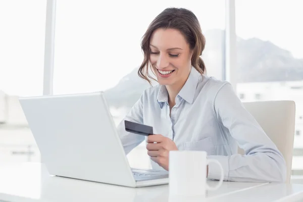 Mujer de negocios sonriente haciendo compras en línea en la oficina —  Fotos de Stock