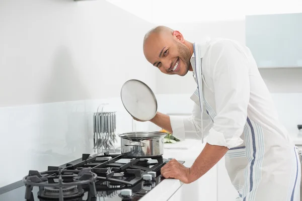 Joven sonriente preparando comida en la cocina —  Fotos de Stock