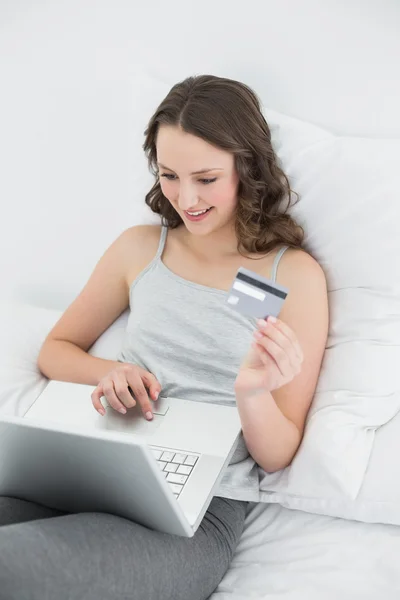 Casual giovane donna che fa shopping online a letto — Foto Stock