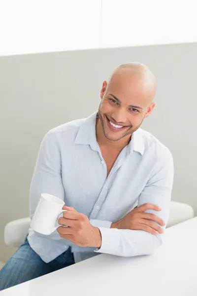 Sorridente bell'uomo che tiene la tazza di caffè a casa — Foto Stock