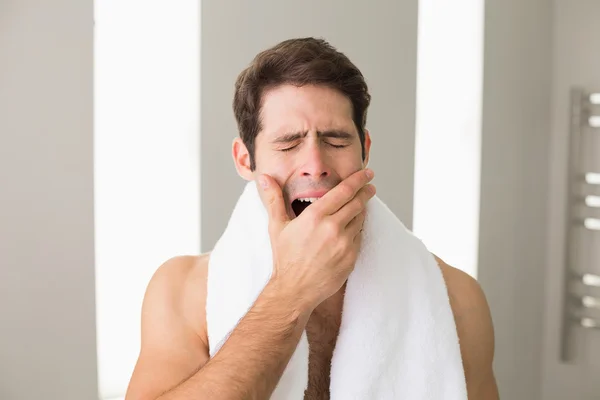 Мужчина без рубашки зевает с закрытыми глазами дома — стоковое фото