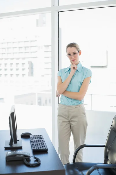 Lugn affärskvinna stående tankeväckande i hennes kontor — Stockfoto