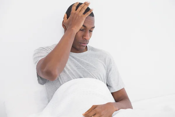 Retrato del hombre afro somnoliento sentado en la cama — Foto de Stock