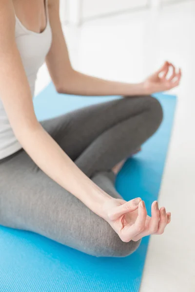 Toned woman sitting in lotus pose at fitness studio — Stock Photo, Image