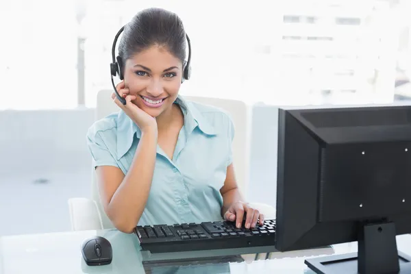 Geschäftsfrau trägt Kopfhörer, während sie Computer benutzt — Stockfoto