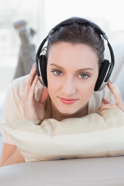 Close up of a relaxed casual woman enjoying music on sofa — Stock Photo, Image