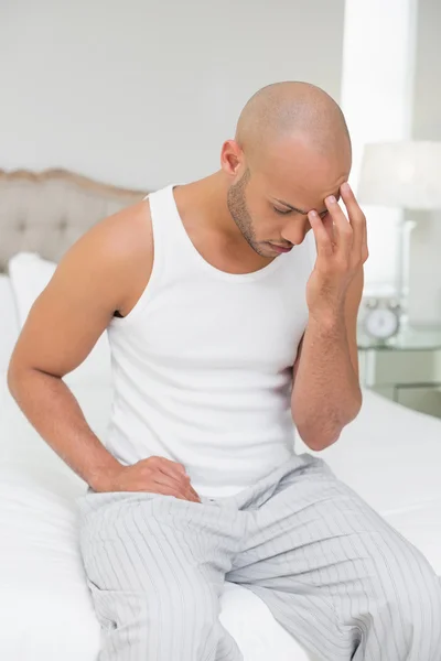 Bald man suffering from headache in bed — Stock Photo, Image