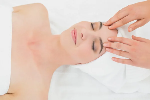 Manos masajeando la frente de una hermosa mujer en el spa de belleza — Foto de Stock