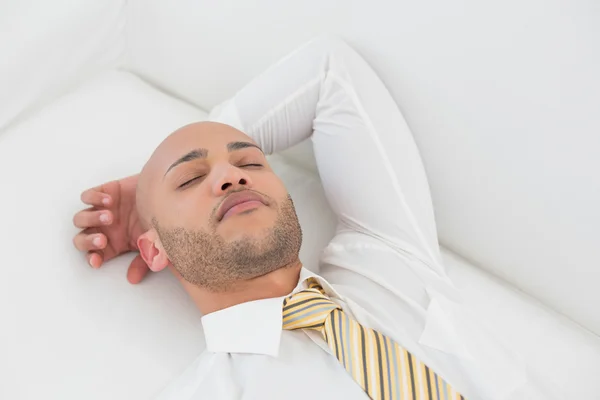 Businessman sleeping on sofa at home — Stock Photo, Image