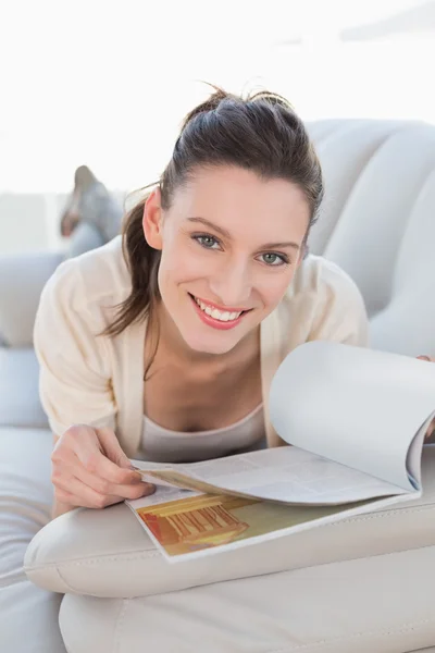 Portrait of a casual woman reading a book on sofa — Stock Photo, Image