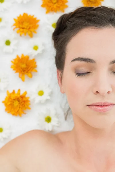 Hermosa mujer con los ojos cerrados y flores en salón de belleza —  Fotos de Stock