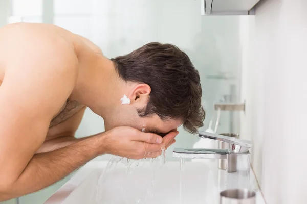 Shirtless mladý muž mytí obličeje v koupelně — Stock fotografie
