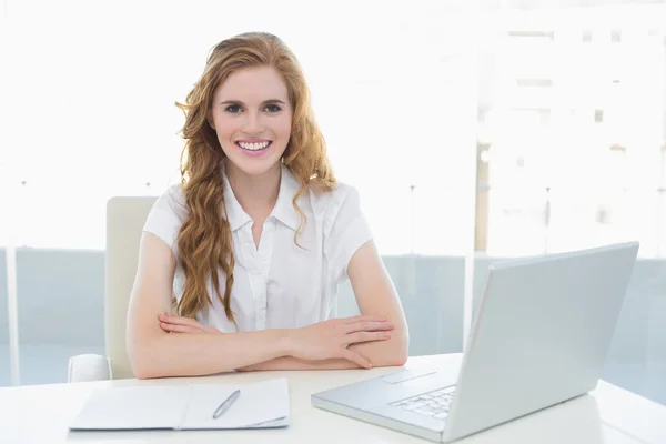 Donna d'affari sorridente con computer portatile in ufficio — Foto Stock