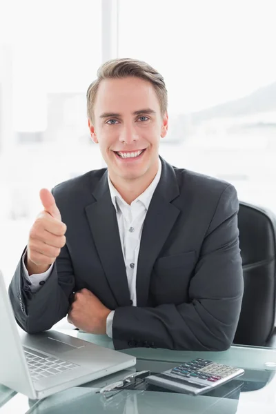 Homme d'affaires avec ordinateur portable geste pouces vers le haut au bureau — Photo