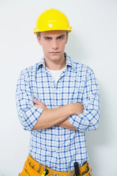 Sérieux bricoleur en casque jaune avec bras croisés — Photo