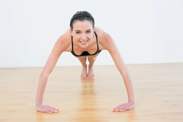 Jonge vrouw doet push ups in fitness-studio — Stockfoto