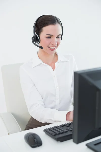 Kobieta nosi słuchawki podczas korzystania z komputera — Zdjęcie stockowe