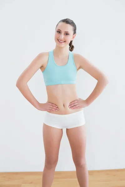 Toned young woman standing against wall — Stock Photo, Image