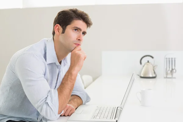 Casual smiling man using laptop at home — Stock Photo, Image