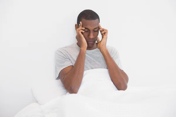 Afro hombre que sufre de dolor de cabeza en la cama —  Fotos de Stock