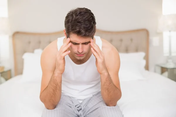 Junger Mann leidet unter Kopfschmerzen im Bett — Stockfoto