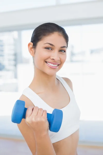 Woman exercising with dumbbell in fitness studio — Stock Photo, Image