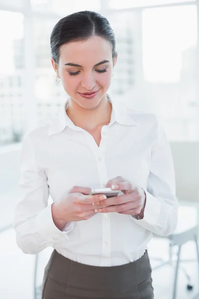 Kobieta, patrząc na telefon komórkowy w biurze — Zdjęcie stockowe