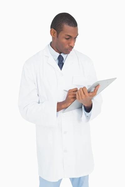Серьезный врач-мужчина пишет на планшете — стоковое фото