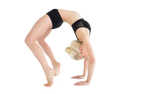 Side view of a fit young woman doing the wheel pose — Stock Photo, Image