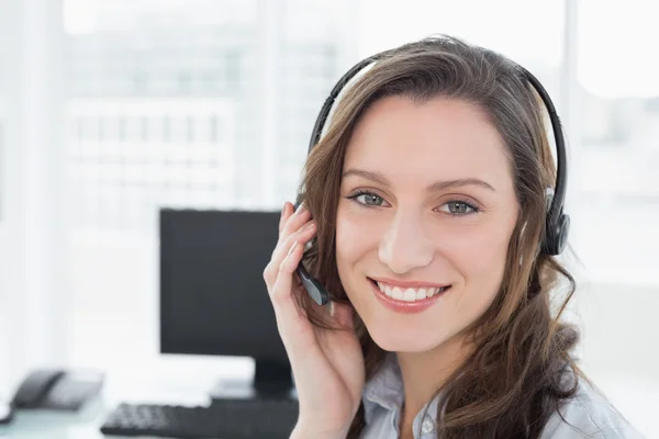 Portret van zakenvrouw dragen hoofdtelefoon achter computer — Stockfoto