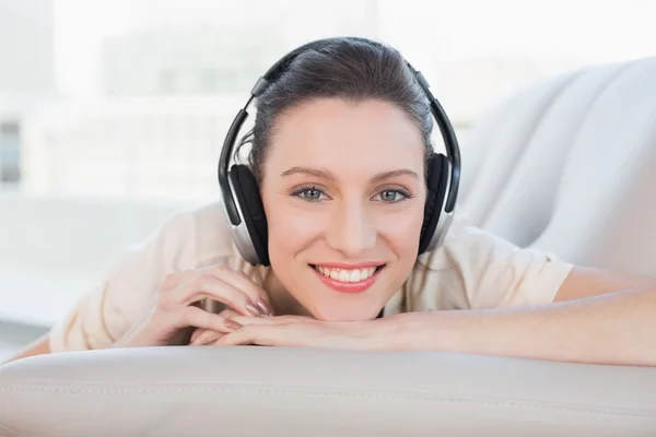 Relajada mujer joven casual disfrutando de la música en el sofá —  Fotos de Stock