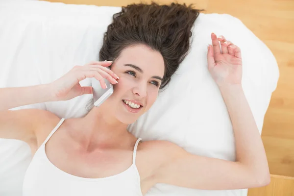 Porträt einer entspannten Frau mit Handy im Bett — Stockfoto