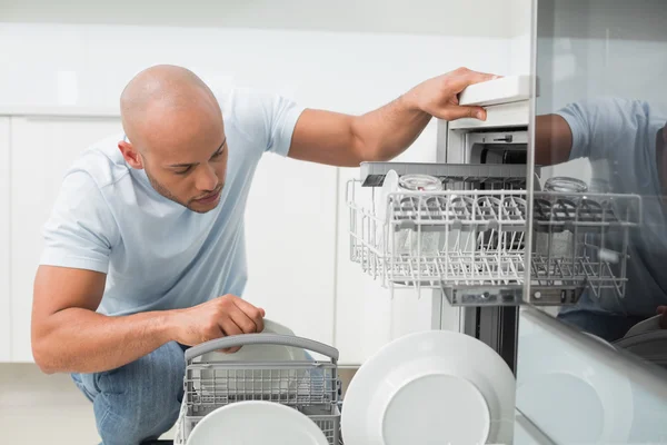 Allvarlig man med diskmaskin i köket — Stockfoto